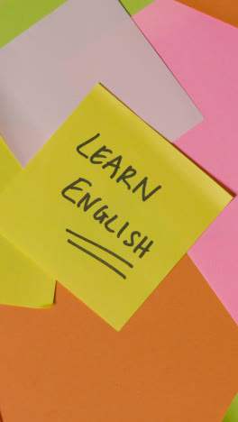 Vertical-Video-Education-Concept-Of-Revolving-Sticky-Notes-With-Learn-English-Written-On-Top-Note